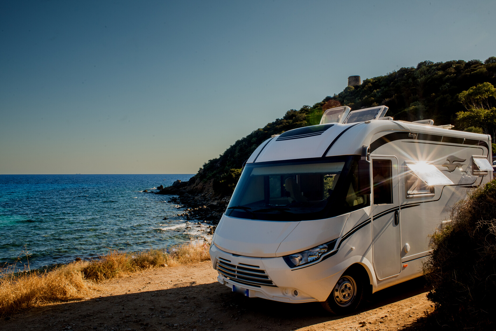 RV Parked Near Ocean at Sunset